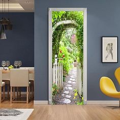 an open door leading into a blue walled living room with a white table and yellow chairs