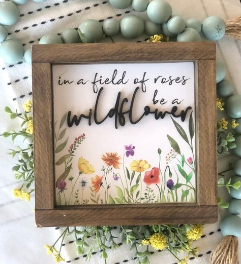 "Framed wood inspirational sign | In a field of roses be a wildflower This solid wood sign will make the perfect gift for your favorite wildflower. It has just the right amount of color to make your decor pop. The graphics are printed directly onto the painted wood. The word wildflower is a 3D laser wood cutout. Sizes - (Available in 3 sizes) - - Sizes are approximate and may vary up to 1/2\" Sizes include - 7\" x 7\" 11\" x 11\" 13\" x 13\" All solid 3/4\" maple plywood sign. Framed in solid pi Wildflower Wedding Sign, Wildflower Kitchen, Wood Board Signs, Plywood Sign, Be A Wildflower, Vinyl Frame, Wildflower Decor, Field Of Roses, Flour Sacks