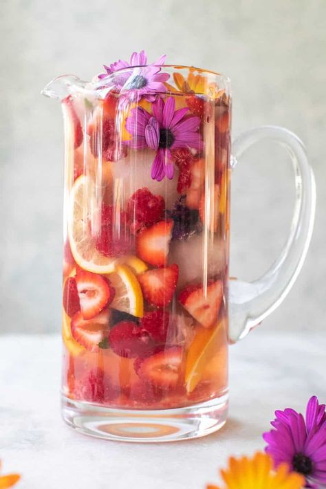 This floral sangria recipe is made with white wine and elderflower liqueur. It's regressing, light, fruity with the most beautiful floral notes throughout. It's refreshing and perfect for spring. #Sangria #WhiteSangria #FloralSangria #SangriaRecipe #Cocktails #SpringCocktails #WineCocktails Spring Punch Recipes Alcohol, Floral Sangria, Elderflower Sangria, Spring Sangria, Floral Drinks, Spring Cocktail Recipes, White Sangria Recipe, Floral Brunch, Spring Cocktails Recipes