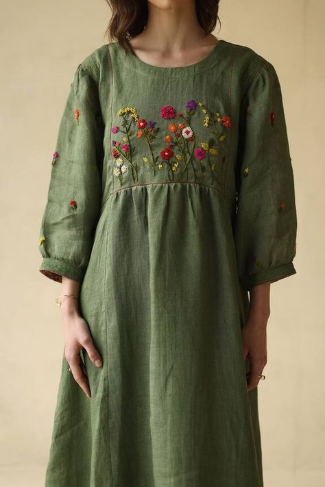 Forest green gauze linen dress with floral embroidered yoke, floral motifs on sleeves, pleats, and lace detailing across the shoulders. Component: 1 Pattern: Embroidered Type Of Work: Floral, Motifs Neckline: Round Sleeve Type: Three quarter Fabric: Gauze linen, Lining : Cotton Color: Green Other Details:  Attached lining Occasion: Work - Aza Fashions Plain Kurti Designs, Yoke Dress, Hand Embroidery Dress, Kurti Embroidery Design, Indian Dresses Traditional, A Line Kurta, Maggam Work Blouse Designs, Dress Design Patterns, Jolly Rancher