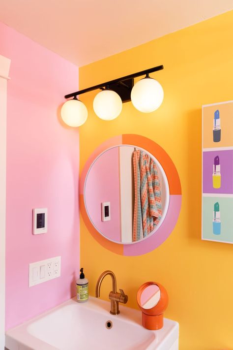 Pink and orange decal around bathroom mirror. Colorful Bathroom Mirrors, Colorful Bathroom Backsplash, Fun Colorful Kids Bathroom, Orange And Pink Maximalist, Colourful Ensuite Bathroom Ideas, Orange Accent Wall Bathroom, Aesthetic Colorful Bathroom, Fun Tiny Bathroom, Yellow Orange Bathroom