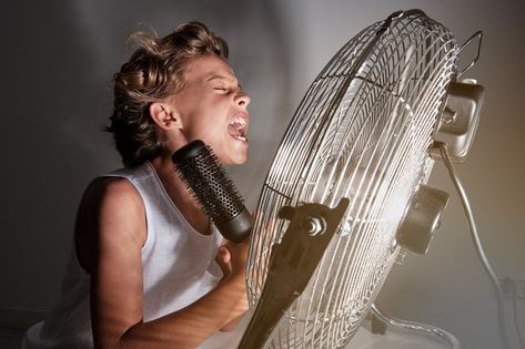 Side view of excited child enjoying cool air from fan and while pretending to sing with hairbrush at home Fan, Side View, Hair Brush, Edison Light Bulbs, Singing, At Home, Quick Saves