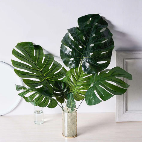 Add a touch of tropical paradise with our Assorted Green Artificial Silk Tropical Monstera Leaf Plants. These stunning leaves are perfect for elevating your décor with a pop of vibrant green. Ideal for Trendy Inspirations and Seasonal Wedding Inspiration, they bring natural beauty and elegance to any home or party space, making your event stand out with effortless charm.