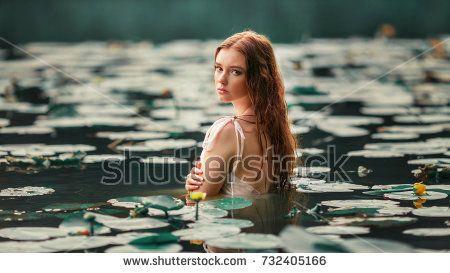 Beautiful red haired girl in white dress posing in river with water lilies. Fairytale story about  ophelia .Warm art work Senior Pictures Water, Lake Portrait, Debut Photoshoot, Lake Photoshoot, Water Shoot, Senior Photo Outfits, Senior Photo Poses, Water Pictures, Girl In Water