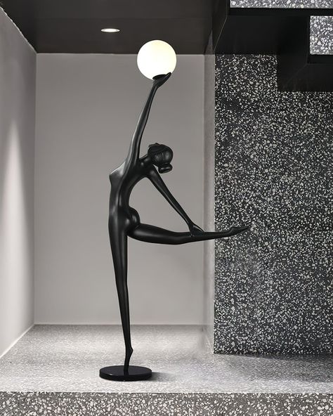 The Rhythmic Gymnast Sculpture Floor Lamp embodies the grace and elegance of a gymnast in motion. This striking piece features a sleek, black figure poised in a dynamic pose, capturing the essence of rhythmic gymnastics. The sculpted form gracefully balances, with one hand delicately holding a glowing globe that serves as the lamp. This design seamlessly combines art and functionality, providing a sophisticated lighting solution that doubles as a stunning artistic statement. Perfect for modern a Ballerina Statue, Orb Of Light, Light Balance, Classic Wall Lights, Floor Lamp Styles, Crystal Wall Lighting, Ballerina Art, Classic Chandeliers, Staircase Chandelier