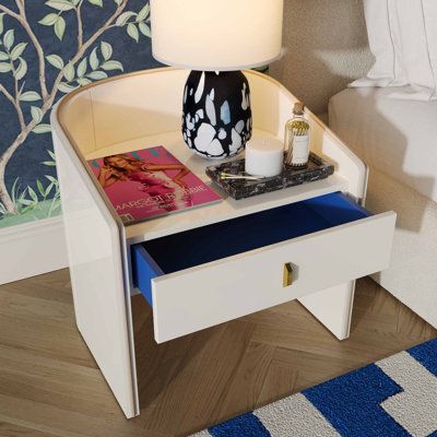 Introducing the Black Lacquer Nightstand: a stunning Art Deco-inspired piece with a retro pop-of-color blue drawer. Its sexy sloped silhouette exudes high-style, while the vibrant blue drawer adds a punchy touch. Elevate your bedroom with this unique and stylish nightstand that combines timeless design with a playful twist. | Hokku Designs Khaleesia Manufactured Wood Nightstand Wood in Brown | 21.5 H x 21.9 W x 19 D in | Wayfair Lacquer Nightstand, Stylish Nightstand, Blue Drawers, Retro Pop, Black Lacquer, Wood Nightstand, Gold Handles, Bedroom Night Stands, Drawer Nightstand