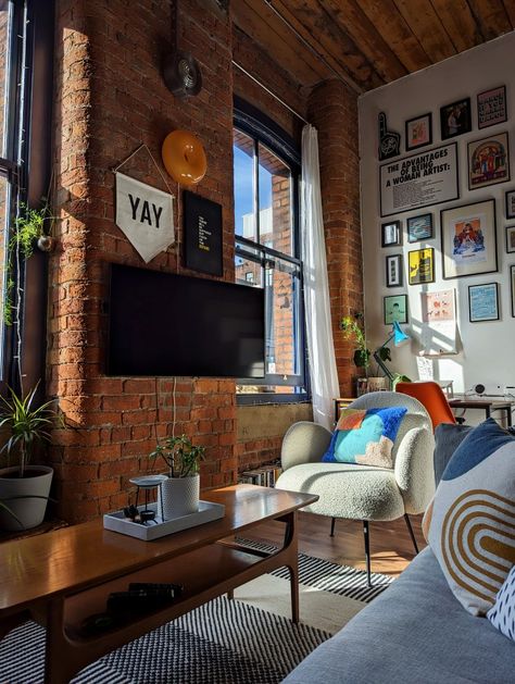 Strong light and shadow against a double-height gallery wall in a loft apartment decorated with colourful homewares and vintage furniture New York Exposed Brick Apartment, White Brick Loft Apartment, Brick Wall Apartment Decor, Boston Apartment Aesthetic Living Room, Exposed Brick Apartment Aesthetic, Brick Wall Room Decor, Colourful Industrial Interior, Loft Exposed Brick, Brick Loft Apartment Decor