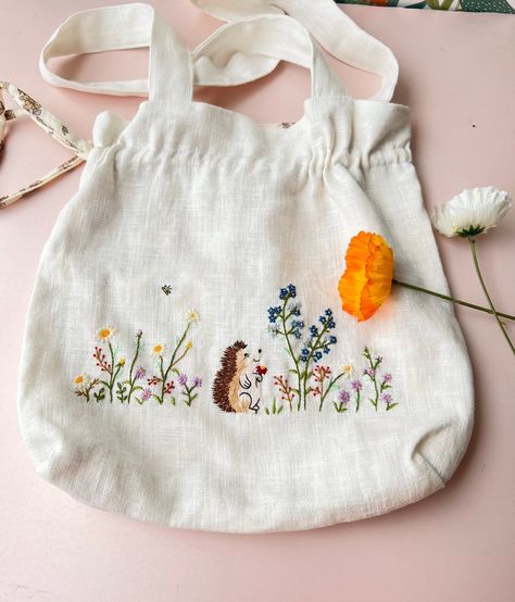 📍Product details: This is our very special bag as you can use both sides of it. The outside is embroidered with beautiful flowers and the inside is lined with floral fabric. So you can change your style whenever you want as both sides of the bag look great. - Material: Linen, inner lining - Dimensions: 30x30cm (11.8" x 11.8"). If you need a custom size, please message us. - Pattern: beautiful flower garden, wild flower, hedgehog and embroidered name (or any text)  - This aesthetic and cute tote bag will add a feminine touch to your outfit & a vintage feel. Perfect for different activities such as shopping, picnic, go to school,.. 📍  You buy this for yourself or give it as a perfect sweet gift for: - Wedding or bridesmaid gifts  - Bachelorette gifts, Back to school gifts. - Best friends g Flower Hedgehog, Hedgehog With Flowers, Tote Bag Embroidery, Drawstring Tote Bag, Garden Wild, Embroidered Bags, Linen Tote Bag, Bag Embroidery, Embroidered Tote Bag