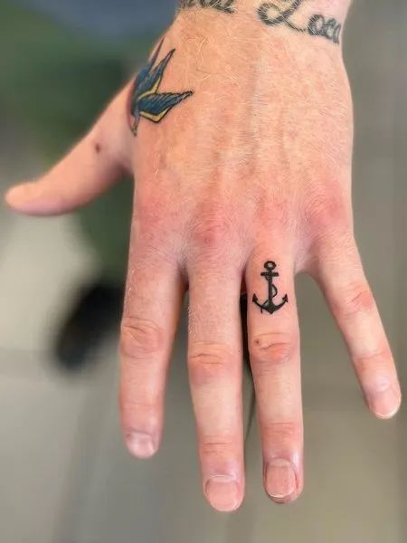 70+ unique and striking finger tattoo designs: symbols, hennas, roses, snakes, dots, lettering, hearts, and wedding rings for couples. Bonus: tattoo meanings. Anchor Finger Tattoo Men, Patchwork, Tattoo Designs Men Finger, Finger Tattoo Men Ideas, Anchor Tattoo Hand, Anchor Tattoo On Finger, Anchor Finger Tattoos For Women, Finger Anchor Tattoo, Small Anchor Tattoo Men