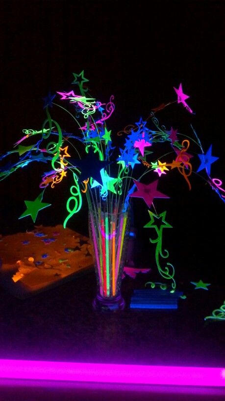 Young womens "Let your talents glow" theamed night in Excellence Centerpiece. All lit up by black light. Stars are made from neon poster board. Glow stick are in base, not cracked to glow. Black light lights them up. Neon Table Centerpieces Glow Party, Dance Party Centerpieces, Glow In The Dark Table Centerpiece, Glow Party Table Centerpieces, Glow Table Decorations, Glow Stick Centerpiece, Neon Theme Centerpieces, Neon Centerpieces Diy, Neon Lights Party Theme