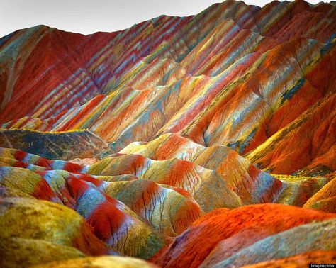 Believe it or not, this technicolor range actually exists.  The mountains are part of the Zhangye Danxia Landform Geological Park in China. Layers of different colored sandstone and minerals were pressed together over 24 million years and then buckled up by tectonic plates. Rainbow Mountains China, Zhangye Danxia Landform, Zhangye Danxia, Danxia Landform, Rainbow Mountains, Matka Natura, Landform, Colorful Mountains, Rainbow Mountain