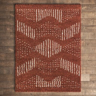 With its chevron pattern and plush texture, this area rug is a cozy foundation in your living space. It's power-loomed from polypropylene, and it showcases a striped and dotted design in warm hues of burnt orange and creamy white. With a plush 1.18" high pile height, it's a good choice for rooms where you like to relax - think your bedroom or sitting room. Best of all, this rug is stain-resistant, so it stands up to the occasional spill and splash. We recommend pairing it with a rug pad (sold se Boho Mid Century Modern Living Room, Burnt Orange Living Room, African Throw Pillows, Cozy Boho Living Room, Orange Kitchen Decor, Dotted Design, Area Rug Sets, Living Room Orange, Kelly Clarkson Home