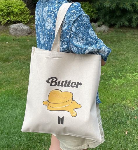 "BTS TOTE BAG IS HERE!  This unique tote bag features an illustration of new album \"BUTTER\" and the logo! Our canvas totes are made with 100% organic cotton and are sturdy that can withstand the wear of daily use.  This tote bag is perfect for your daily use as grocery tote, book tote or even as an inexpensive gift for friends and family!  Material: 100% Organic Cotton Canvas Weight:: 5 Oz Strap:: 21 inch handle Compartment Size:: 15\"W x 16\"H" Tela, Kpop Illustration, Bts Tote Bag, Tote Bag Bts, Tote Bag Kpop, Tote Bag Illustration, Diy Bag Painting, Merchandise Kpop, Painted Canvas Bags