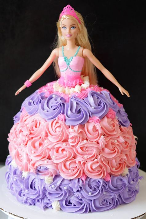 Barbie cake on a white cake pedestal. Barbie Cake Diy Easy, Doll Princess Cake, Barbie Cake How To, Barbie Cake Recipe, Princess Dress Cake Birthday, Easy Barbie Birthday Cake, How To Make A Princess Cake, Barbie In Cake, How To Make A Barbie Dress Cake
