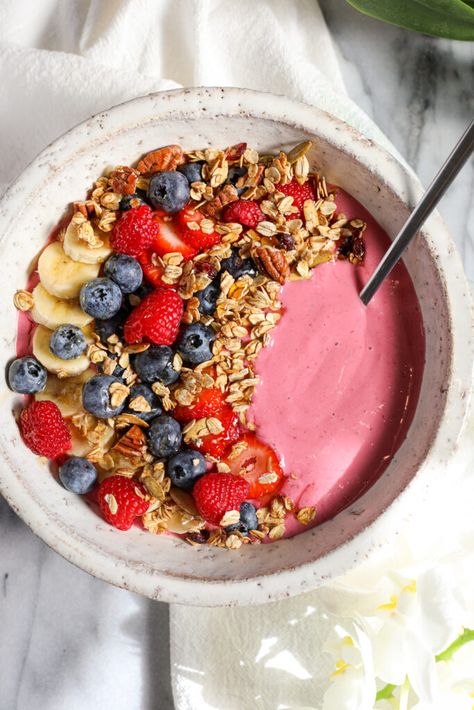 This raspberry smoothie bowl is made with raspberry yogurt and frozen berries. It is bright, fresh, and healthy, topped with fresh fruit, crunchy granola and a drizzle of honey. Topping the smoothie bowl with granola provides extra protein, which keeps me full until lunch time. With nothing other than yogurt and frozen berries, it is a great way to start the day, especially knowing that you’ve had a good-for-you breakfast. It helps you to feel lighter with more energy in the morning. Yogurt With Granola, Energy In The Morning, Berry Granola, Raspberry Smoothie Bowl, Fruit Granola, Yogurt Frozen, Raspberry Yogurt, Extra Protein, Cold Cereal