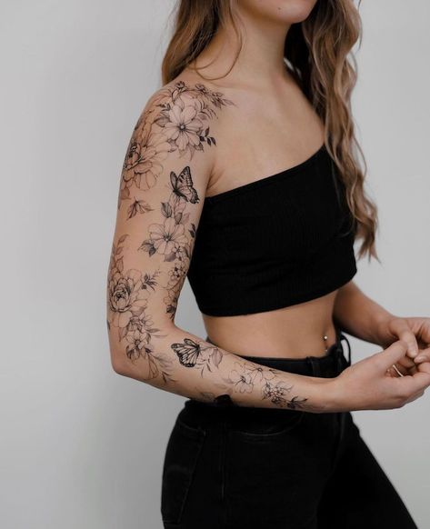 21 Tattoo Sleeves For Women From Feminine To Edgy Edgy Arm Tattoos For Women, Fine Line Floral Shoulder Tattoo, Scattered Sleeve Tattoo, Woman Arm Sleeve Tattoo, Bold Tattoos For Women, Minimalist Sleeve Tattoo For Women, Whole Arm Tattoo, Feminine Sleeve Tattoo Ideas, Back Arm Tattoo Women