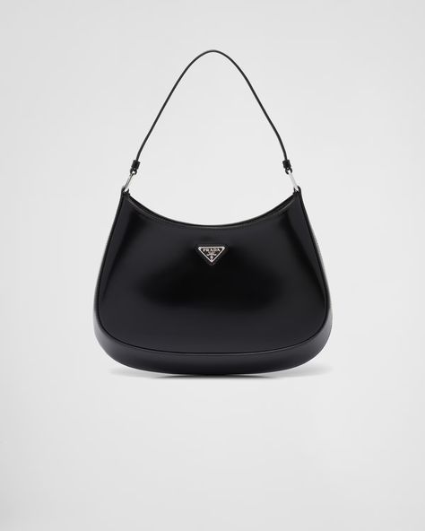 The Prada Cleo bag with sophisticated allure reinterprets an iconic design of the brand from the 1990's. Sleek curved lines emphasized by the particular construction rounded on the bottom and sides give this hobo bag a soft, light look. Brushed leather, a modern and versatile material that is distinctive in Prada collections, is ideal for creating always new combinations and contrasts. The enamel triangle logo decorates the silhouette. Prada Cleo Bag, Prada Mini Bag, Cleo Bag, Shoulder Bag Prada, Prada Cleo, Prada Nylon Bag, Bags Prada, Prada Women, Prada Collection