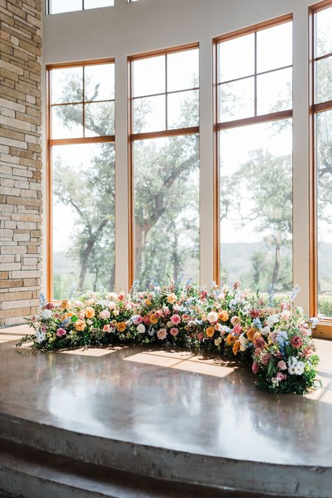 Grounded Crescent Floral Ceremony Arch; ground flower meadow wedding flowers; From the outset, they envisioned a celebration that embraced the natural beauty of a garden wedding flowers setting, with blooms that echoed the colors of a bright summer day. Ground Arch Floral, Indoor Spring Wedding Ceremony, Floral Arch On The Ground, Half Circle Ceremony Flowers, Ground Altar Wedding, Floor Floral Arch, Flower Meadow Wedding Ceremony, Ceremony Meadow Arrangement, Semi Circle Floral Ceremony