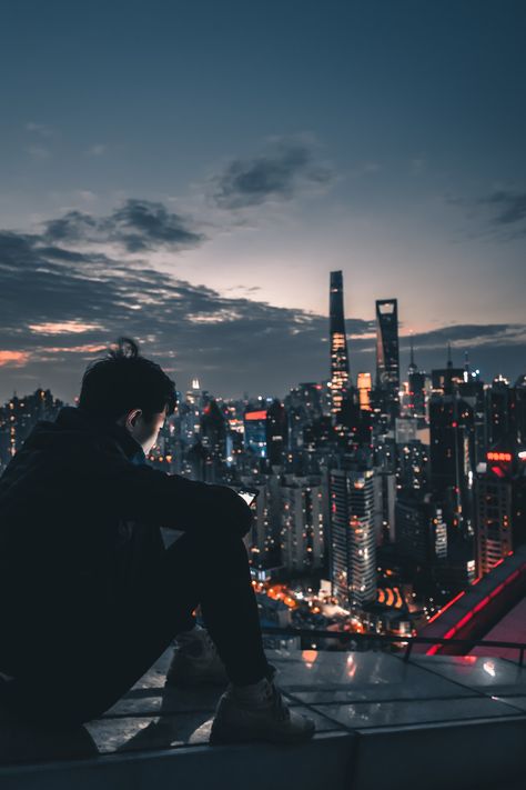 man sitting on roof top during nighttime photo – Free Human Image on Unsplash On Roof Aesthetic, Sitting On Roof, Fotografi Urban, Foto Logo, Fotografi Kota, Images Background, Cyberpunk City, Tapeta Pro Iphone, Ocean Wallpaper