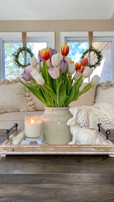 Tulips styled in a crock on a tray with a white ceramic bunny and a candle on the coffee table in front of the sofa with windows behind it. Spring Decor Dining Room Table, Tulip Centerpiece Easter, Cute Spring Decor, Spring Home Decorations, Spring Modern Decor, Spring Decor Bathroom, Spring Time Decorations, Spring Summer Living Room Decor, Home Spring Decor