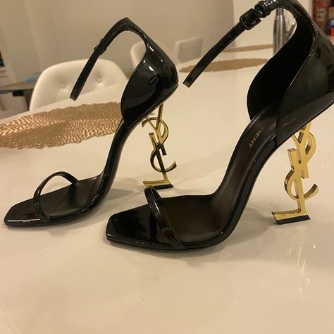 Saint Laurent Black Opyum In Patent Leather with Gold-tone Heel Sandals Black And Gold Ysl Heels, Yves Saint Laurent Heels Aesthetic, Tacchi Saint Laurent, Saint Laurent Shoes Aesthetic, Talon Yves Saint Laurent, Salto Saint Laurent, Loubitons Heels, Ysl Heels Aesthetic, St Laurent Heels