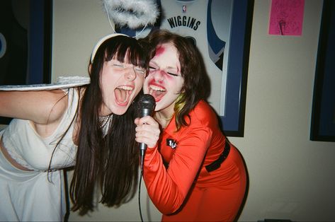 halloween party angel singing screaming into microphone film fujifilm disposable friends aesthetic Someone Singing Reference, Scream Singing Aesthetic, People Singing Reference, Art Reference Photos Friends, Two People Singing Reference, Person Holding Fan Reference, Singing With Microphone Pose, Two People Hanging Out Reference, Screaming Into Microphone