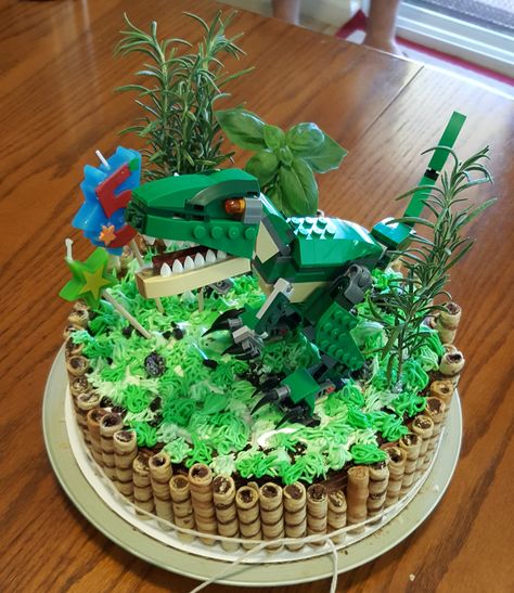 Dinosaur cake for my daughter's birthday. Lego T-Rex, crushed oreo as rocks/dirt , fresh rosemary and basil for decoration (stems wrapped in foil ) Essen, Lego Dinosaur Birthday Party, Dinosaur Lego Cake, Dinosaur Lego Birthday Party, Lego Dinosaur Cake, Lego Dinosaur Party, Dino Lego, Birthday Ideas For Boys, Joey Birthday