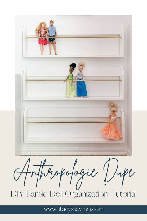 White thin magazine rack style wall racks with a thin gold rod to hold dolls in place standing up. Great use of space to display dolls and keep their hair from getting tangled. Three modern-styled racks hung one above the other on a white wall for maximum Barbie Doll Storage. Barbie Doll Wall Storage, Barbie And Doll Storage Ideas, Kids Doll Storage, Playroom Organization Dolls, Storage For Dolls, Barbie Shelf Storage, Playroom Doll Storage, Storage For Barbie Dolls, Barbie Storage Ideas Diy