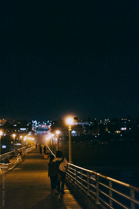 Lovers walk arm-in-arm down Manhattan Beach Pier at night in Los Angeles. by Holly Clark Night Walking Aesthetic, Manhattan Beach Pier, Dream Dates, Look Wallpaper, Dream Night, Beach At Night, Night Couple, Beach Night, Night Vibes
