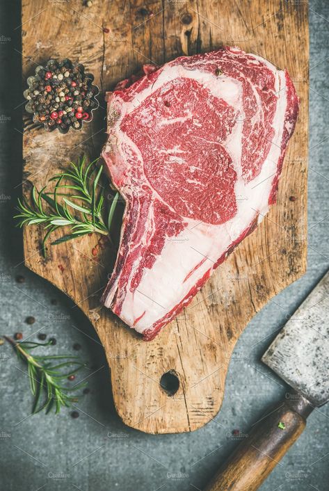 #Raw beef steak rib-eye on board  Flat-lay of raw uncooked prime beef meat dry-aged steak rib-eye on bone with seasoning and chopper on rustic wooden board over grey concrete background top view. Meat high-protein dinner concept Essen, Meat Food Styling, Raw Steak, Carnicerias Ideas, Meat Art, Raw Beef, Dry Aged Steak, Raw Photography, Meat Restaurant