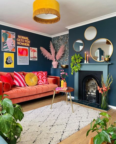 Colorful living room with a fireplace and orange velvet sofa Modern Trendy Living Room, Colorful Couches Living Room, Pink Orange Yellow Living Room, Funky Living Room Wallpaper, Retro Living Room Aesthetic, Green Maximalist Living Room, Bright Color Living Room, Small Eclectic Living Room, Vibrant Living Room Ideas