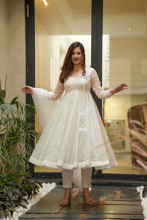 A statement silhouette and color that come together to make this organza suit set a winning pick for the festivities. The kurta comes in anarkali shape with all over embroidery and sequin work, Tassels on the side of the neckline along with solid pants. To complete the look it comes with a white dupatta in organza fabric. KURTA: Colour - White Length- 47-48” Top Shape - Anarkali Neck - Round Neck Pattern/Print - All over Embroidery & Sequin Work Sleeves - 22” Fabric - Organza BOTTOM: Type - Pant Anarkali Dress White Color, White Organza Suit, Organza Suits Indian, Sequins Suit, Silk Anarkali Gown, Dupatta Pattern, Organza Suit, White Dupatta, Sequin Suit