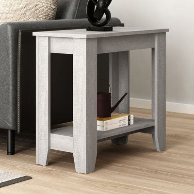 This narrow end table adds a traditional look and extra surface space to your living room or bedroom. Its rectangular frame is made from engineered wood with a rustic finish of your choice that highlights the natural wood scoring and rubs through. This table features four straight legs and tapered feet, with a lower shelf that's ideal for stylized storage boxes and baskets. We love that it has a box apron and a bracket apron along the bottom. Plus, the tabletop offers enough room for a table lam Narrow Side Table, Tall End Tables, Floor Shelf, End Table With Storage, Rustic Cabinets, Storage Wood, Solid Wood Flooring, End Table Sets, Wood End Tables