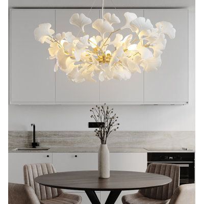 Introducing the exquisite Ginkgo leaf dining pendant, a masterful fusion of iron and ceramic plastics, meticulously adorned with a refined plating finish. This chandelier stands as a testament to opulence and sophistication, elevating your dining environment to unparalleled heights. With an elaborate design featuring ten G9 bulbs, it bathes your space in a warm 3000k glow, perfect for creating an ambiance conducive to exceptional dining experiences. The ceramic plastic ginkgo leaves, meticulousl Ginkgo Chandelier, Kitchen Island Hanging Lights, Dining Pendant, Branch Chandelier, Silver Chandelier, Kitchen Island Lighting Pendant, Ginkgo Leaf, Kitchen Pendant Lighting, Gold Chandelier