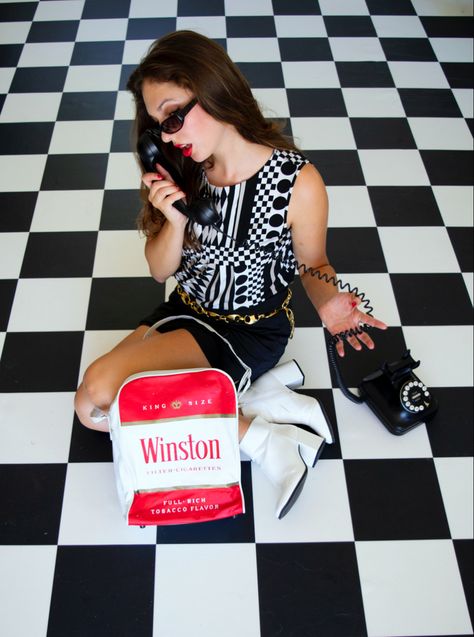 Girl laying on checkerboard floor with vintage phone. Wearing gold hoops, red lipstick, white gogo boots , black mini skirt, checkered and Calvin Klein flowy top. Fashion shoot also includes a vintage 70s Winston purse. 30th Birthday, Checkered Floor Photoshoot, Floor Photoshoot, Checkered Floor, Checkerboard Floor, Checkered Floors, Garage Floor, Thrift Fashion, Fashion Shoot