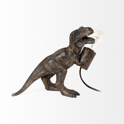 Crafted from resin and finished in a dark tone with immaculate detail, this is a unique table lamp inspired by Tyrannosaurus Rex. This hosts a single E26 bulb in its hands and casts a warm ambient glow. | Trinx 10.62" Black Table Lamp Resin in Black / Brown | 10.5 H x 12 W x 6 D in | Wayfair Dinosaur Table, Dinosaur Tree, Dinosaur Lamp, Unique Table Lamp, Architect Lamp, Brown Lamps, Black Table Lamp, Stylish Table Lamps, Unique Table Lamps