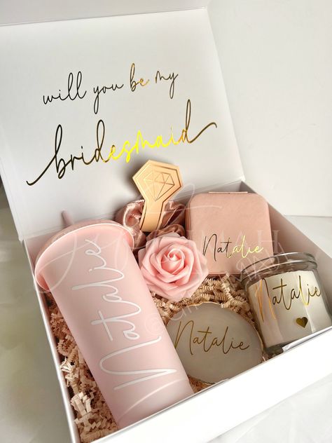 These beautiful pink and gold themed deep large filled boxes make the perfect gift for your bride tribe, packed with an excellent variety of personalised goods these are sure to make the best surprise! Value works out much better than purchasing each item individually! Details: EVERY ORDER COMES WITH: -White magnetic box: 11"x8"x4" Personalised with gold name and inside message. Comes with ivory crinkled paper inside. Tied with pink frayed ribbon. -Pink foam rose ITEMS INCLUDED IN BOX WILL VARY Bride Made Gifts Ideas, Best Bridesmaids Gifts, Bridesmaid Proposal Pink, Bridesmaid Gift Boxes Wedding Day, Crinkled Paper, Light Pink Bridesmaids, Gift For A Bride, Bridal Gift Box, Bride Birthday