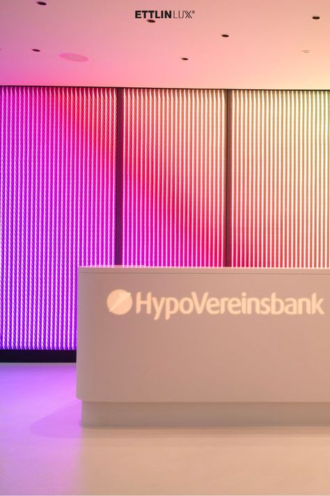 The foyer and reception area from the HypoVereinsbank in Hamburg is an eye-catcher due to a room-high media screen with ETTLIN LUX® Miracle and changing light effects. Architecture Desk, Dynamic Light, Reception Lobby, Movable Walls, Lobby Lounge, Reception Counter, Lobby Interior, Counter Design, Reception Area