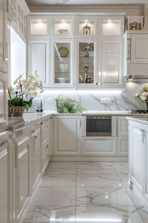 Revel in the beauty of white kitchens, where every detail from cabinets to walls is thoughtfully considered. The backdrop created by a sophisticated backsplash and a functional accent island offers a blend of style and practicality. Modern White Marble Kitchen, Marble Kitchen Flooring Ideas, Elegant White Kitchen Design Ideas, White Marble Floor Kitchen Ideas, White Kitchen Marble Floor, Coastal White Kitchen Ideas, Origami White Kitchen Cabinets, Marble Floor Kitchen Ideas, Marble Kitchen Flooring