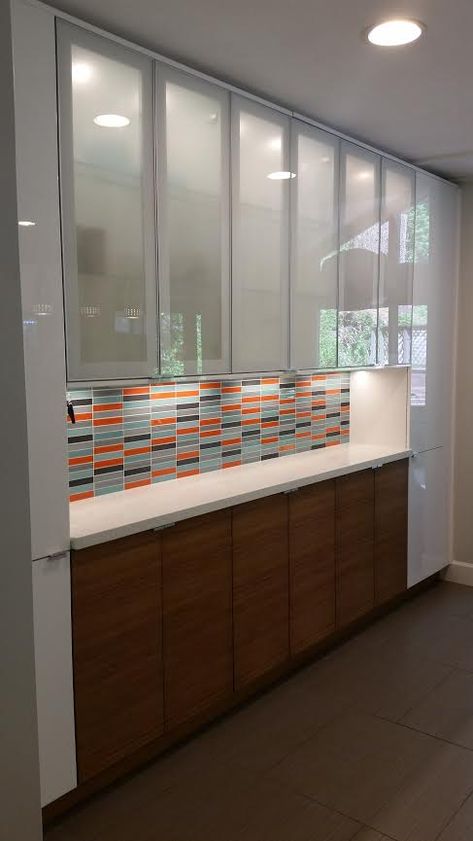 An eye-catching custom orange, blue, and grey glass tile backsplash complements this chic modern kitchen design with mysterious frosted glass front cabinets. http://www.susanjablon.com/5228102.html Frosted Glass For Kitchen Cabinets, Kitchen Cabinets With Frosted Glass Doors, Profile Glass Doors Kitchen, Aluminium Profile Shutter Kitchen, Kitchen Profile Glass Design, Modern Kitchen Cabinet Design Glass Doors, Glass Cabinets Kitchen Modern, Frosted Glass Kitchen Cabinets, Kitchen Cabinets Glass Doors