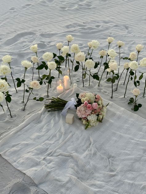 Roses In Sand Proposal, Beach Proposal White Roses, Engagement At The Beach, White Flower Proposal, Beach Engagement Decorations, Proposal Ideas White Roses, Engagement Party Surprise Wedding, Beach Engagement Setup Ideas, Engagement Set Up Ideas Beach