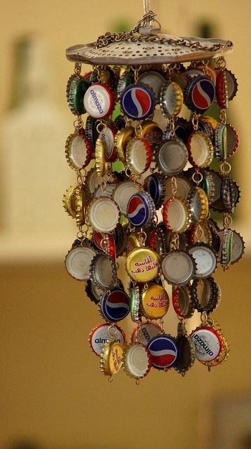 I'm gonna do this!  what a great idea for bottle caps. i was going to use them for tiles on an outdoor table top but this is cute too! Bottle Top Crafts, Carillons Diy, Diy Wind Chimes, Bottle Cap Crafts, Diy Outdoor Decor, Beer Caps, Diy Bricolage, Pola Gelang, Seni Origami