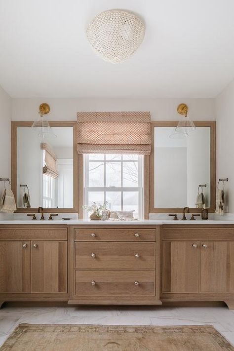 Cottage style bathroom features brushed oak washstands topped with marble countertops illuminated by glass and brass conical sconces over light brown oak mirrors and a light brown vintage runner. Round White Mirror, Oak Bathroom Cabinets, Transitional Bathroom Design, Cottage Style Bathrooms, Pure Salt Interiors, Kate Marker Interiors, Rust Belt, Fiddle Fig, Cottage Bathroom