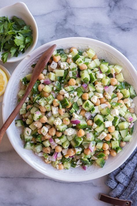 This Herby Cucumber Salad with Feta and Chickpeas is flavorful, refreshing and easy to make!  It's a great side dish for a potluck or BBQ, but is also delicious stuffed into a warm pita for lunch.  You only need a few simple ingredients to make this tasty summer salad! #summersalad #cucumbersalad #BBQSide #easyrecipe #vegetarian #chickpeasalad Salad With Chickpeas And Salami, Chickpeas And Feta, Potluck Recipes Salad, Chickpeas Cucumber Salad, Chickpeas And Cucumber Salad, Easy Tasty Salads, Herby Cucumber Salad With Feta And Chickpeas, Cucumber Salad Meal Prep, Lunch With Cucumber