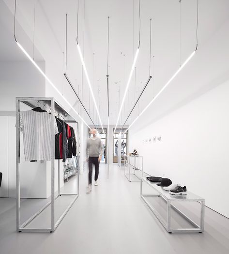 this streetwear store in porto portugal sets the stage for the minimalist clothing it offers. diogo aguiar studio designed the space with straight rigid lines in order to accentuate the store’s high ceilings and expansive length. one gets the impression of a much larger space. Streetwear Bedroom Ideas, Streetwear Bedroom, Minimalist Streetwear, Retail Lighting, Clothing Store Design, Retail Interior Design, Interior Minimalista, Retail Store Design, Boutique Interior