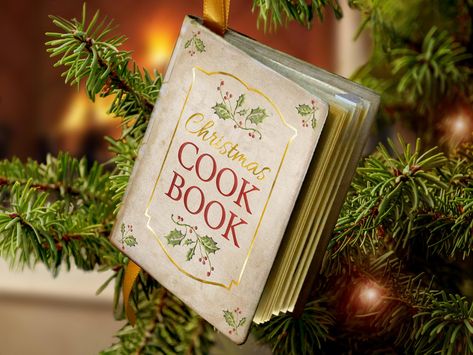 This Christmas ornament is a pocket-sized cook book of traditional Christmas recipes. It contains 18 pages of traditional Christmas recipes from both the US and England.  The hard cover is made to look like an antique book, with paper and card stock components and sprayed with a sealer to preserve the ornament and enhance the vintage texture.  A gold satin ribbon serves as a book mark and a loop with which to hang the book on a Christmas tree as an ornament. The book measures 3" x 2.5".     Recipes Included: Sugar Cookies Mince Pies Cranberry Orange Cake Christmas Pudding Christmas Dressing (stuffing( Honey Butter Shallots Honey Glazed Ham Fudge Sandies Peppermint Hot Cocoa Pigs in a Blanket Gingerbread Men Cranberry Cider Eggnog Cranberry Sauce This ornament can be personalized with custo