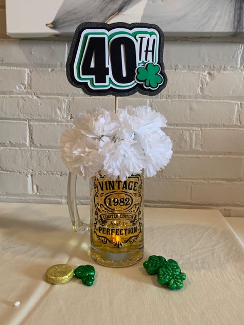 Dollar store mug, flower, shamrock & gold coins. 
Black vinyl and stencil on cricut
40th sign made out of layered card stock using cricut. Filled with colored water and added clear water beads from Craft store. Aged To Perfection Party Centerpieces, 40th Birthday Ideas For Men Centerpieces, 50th Birthday Table Centerpieces For Men, 40th Bday Centerpieces For Men, 30th Birthday Centerpieces For Men, 60th Birthday Centerpieces For Men, 40th Birthday Centerpieces For Men, Beer Centerpieces For Men, Birthday Centerpieces For Men