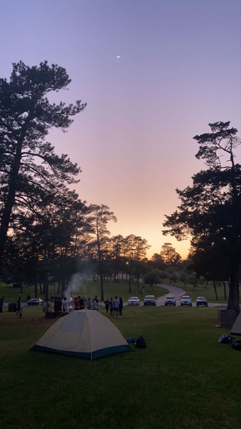 sunset view of some people camping in a nature park; there is a tent set up, trees, and white smoke coming up from a campfire Tent Aesthetic Camping, Sunset Nature Aesthetic, Camping Aesthetic Friends, Camping Aesthetic Outfits, Camping Background, Tent Camping Aesthetic, Camping Sunset, Aesthetic Nature Photography, Nature Parks