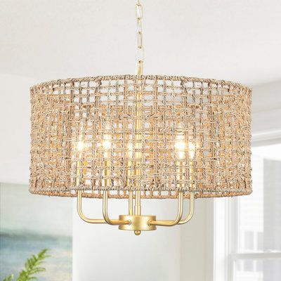 Make a style statement with the coastal-inspired organic chandelier light. It features a black canopy and hand-woven drum shade which is crafted of natural rattan/seagrass. It's a unique blend of eclectic nautical and rustic vintage styles. Filtering the light from within, each piece creates a play of light and subtle shadow in a room, adding an inviting ambiance. Finish: Spray Gold | Bay Isle Home™ Ekkehard 5 - Light Dimmable Drum Chandelier Metal in Yellow | 70.86 H x 11.33 W x 18.89 D in | Wa Rattan Kitchen Chandelier, Ballard Design Bamboo Chandelier, Rattan Shade Chandelier, Seagrass Light Fixture, Ceiling Lights Over Dining Table, Light Above Kitchen Table Coastal, Rattan And Gold Decor, Farmhouse Wood Chandelier, Beachy Chandelier Dining Room