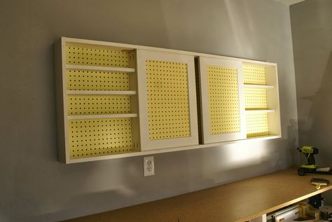 wall-mounted pegboard tool cabinet with sliding doors, tutorial featured on Remodelaholic.com Sliding Cabinet Door, Sliding Cabinet Door Hardware, Garage Wall Cabinets, Plastic Cabinet, Pegboard Garage, Cabinet Doors Repurposed, Sliding Cabinet, Sliding Cabinet Doors, Old Cabinet Doors